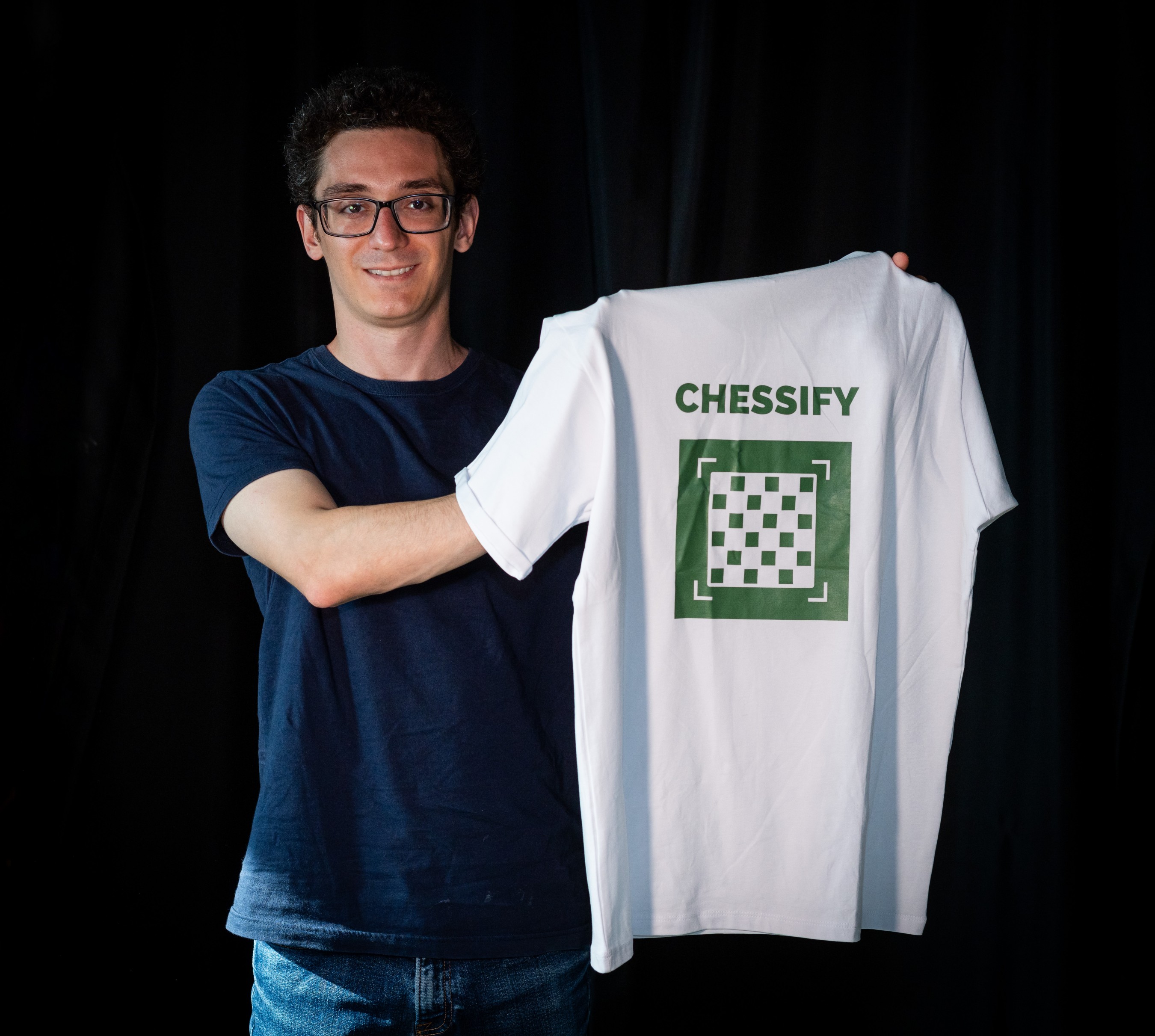 Fabiano Caruana holding Chessify's t-shirt